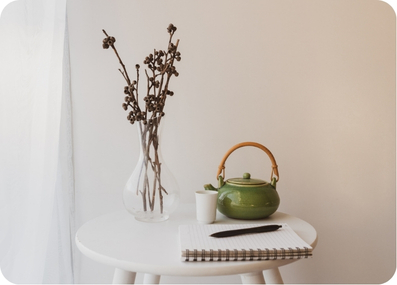 A calm still life with a teapot and dried botanical stems